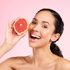 Grapefruit, beauty and face of happy woman with skin care, dermatology or natural glow. Portrait of a female model with fruit for vitamin c, cosmetics or healthy diet for detox on studio background