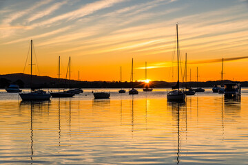 Beautiful sunrise with high cloud and boats on the water