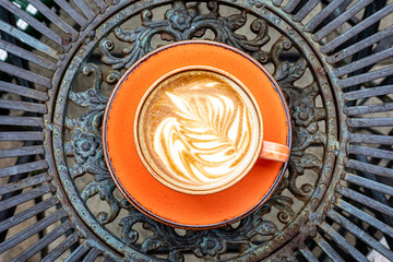 Morning cup of coffee latte from above on a metal table