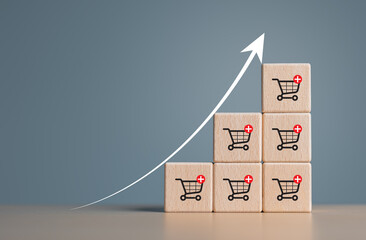 Wooden cubes with shopping cart icons and increasing trend-up graph. Increase higher sale volume...