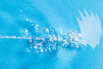 Close up of air bubbles, water ripples and waves with copy space on blue background