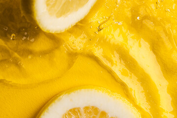 Fototapeta na wymiar Close up of lemon slices in water with copy space on yellow background