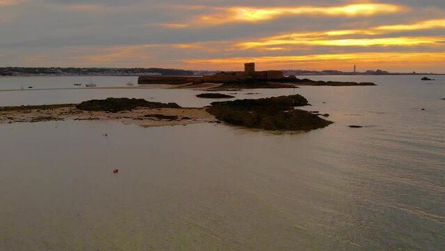 Aerial Drone slow vertical ascent looking towards St Aubin's Fort in the town of St Aubin, Jersey, Channel Islands