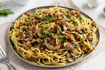 Homemade Mushroom, Spinach & Sausage Spaghetti on a Plate, side view. Close-up.