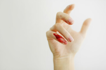 Female hand with red blood, little finger is bleeding profusely. Woman injured her little finger at...