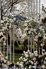 Luxury wedding ceremony area, geometric lines with white and pink flowers, front view.