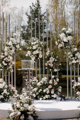 Luxury wedding ceremony area, geometric lines with white and pink flowers, front view.