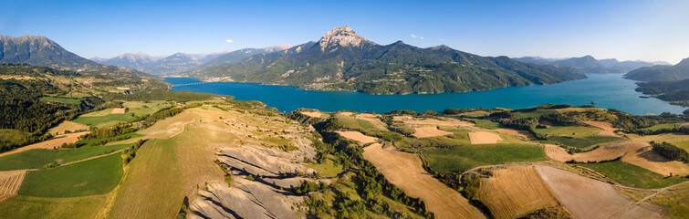 Panoramic aerial view of Serre-Poncon Lake and Grand Morgon peak with village of Savines-le-Lac and...