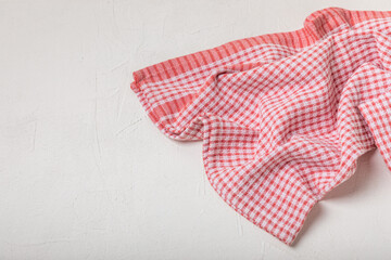 Kitchen towel on a light textured background. Kitchen utensils and textile napkin. A stack of cotton towels on the table. Home decor. Tablecloth for the table. Copy space for text. Mockup for design.