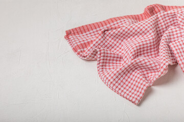 Kitchen towel on a light textured background. Kitchen utensils and textile napkin. A stack of cotton towels on the table. Home decor. Tablecloth for the table. Copy space for text. Mockup for design.