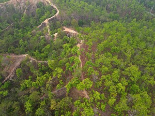 The epic Pai Canyon in Pai, Thailand taken from above from the bird's eye view with the drone surrounded by trees.