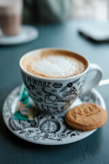 A delicious cappuccino with a cookie