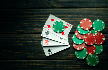 Poker game with four of kind combination. Chips and cards on the dark vintage table. Successful and maximum win