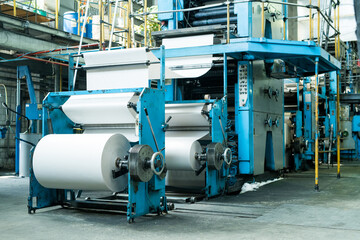 Large printing press with paper roll printing newspaper on production line of industrial printing machine