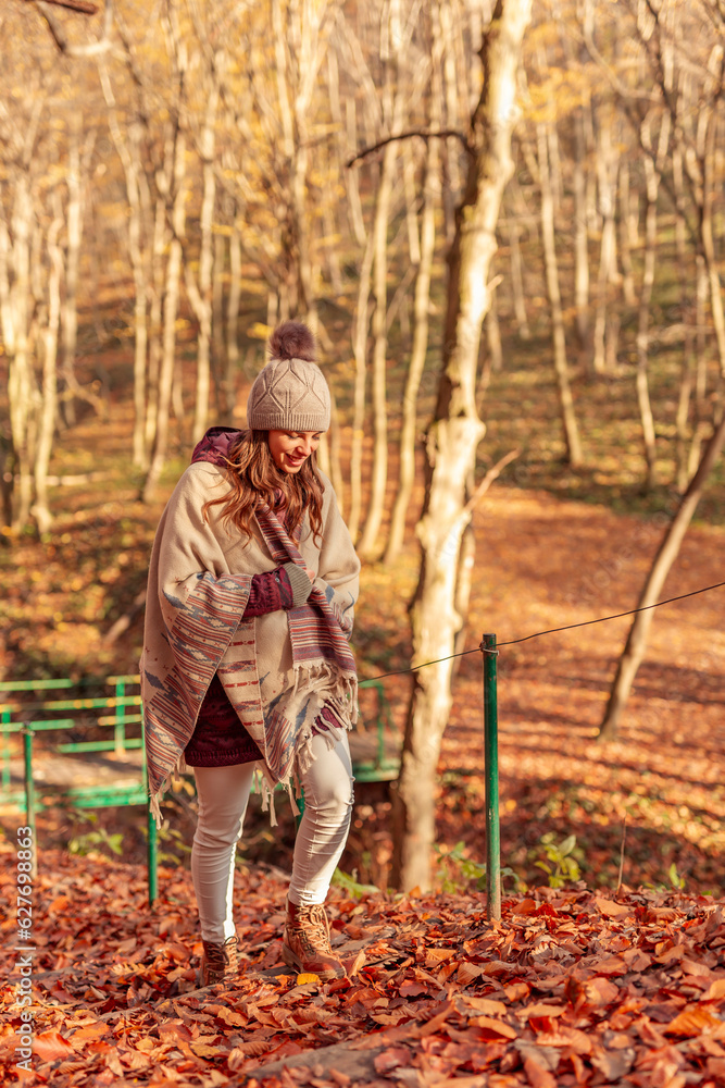 Wall mural Woman walking through the forest on an autumn sunny day