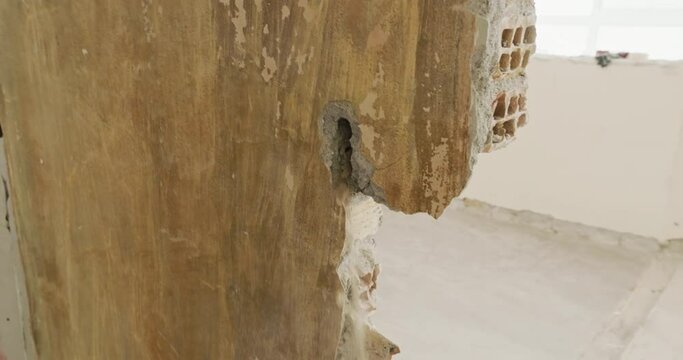 Dismantling the walls in the premises, the builder removes the plaster with a jackhammer. Hard work at the construction site dismantling walls and structures. High quality 4k footage
