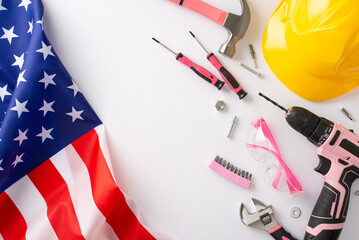 Commemorating the impact of women's labor on Labor Day. High-angle photo displaying an American flag, and building tools on white isolated background with copyspace for ads or text placement
