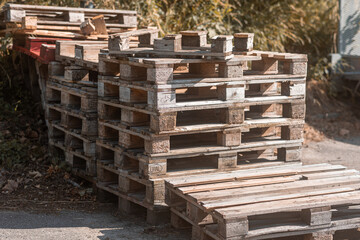 Euro pallets stacked in corner of industrial area.