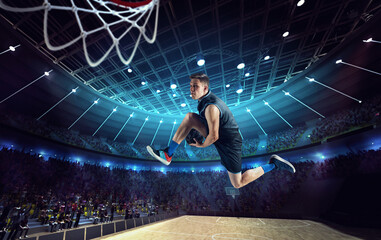Slam dunk. Young man, professional basketball player on 3D stadium, arena during game, jumping with...
