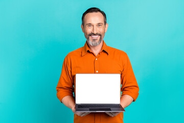 Photo of intelligent cheerful smart man wear stylish shirt hold laptop presenting empty space...