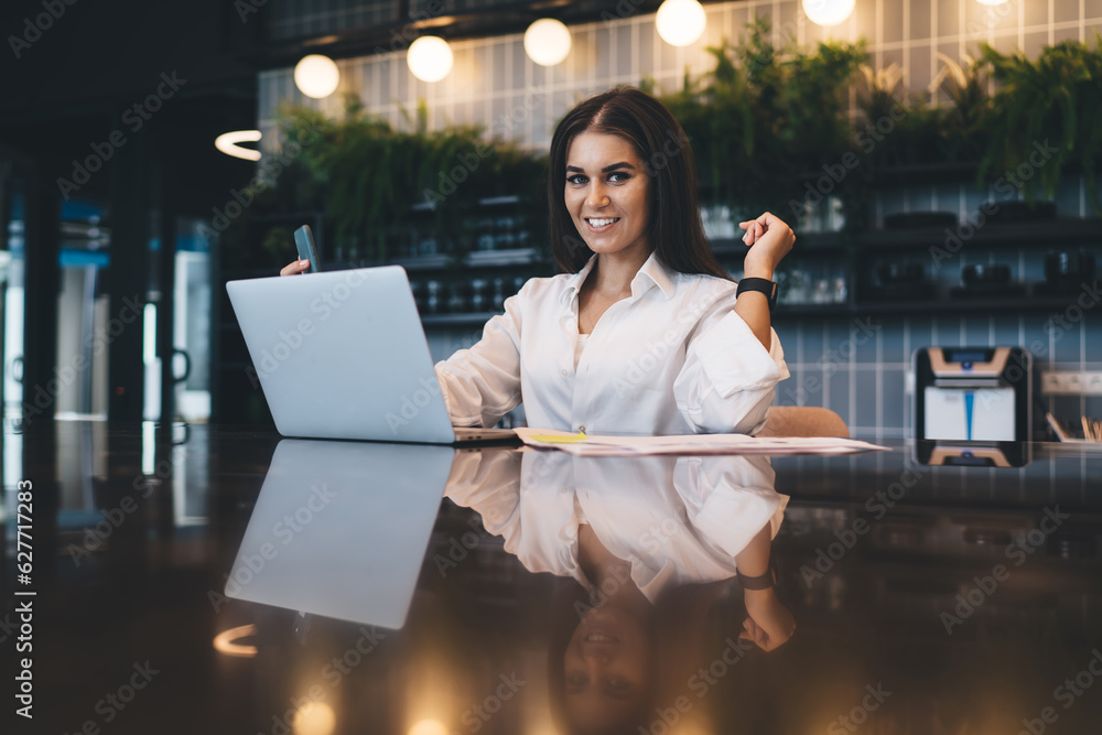 Poster charming smiling worker with devices in workspace