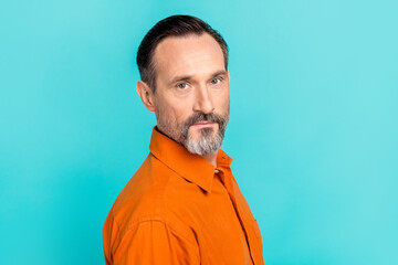 Photo of cool charming man dressed orange shirt looking you isolated turquoise color background