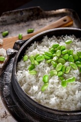 Wholesome Fusion: Top Close-Up of Edamame Served on Steamed White Rice in a Cast Iron Pot, Captured in 4K Resolution