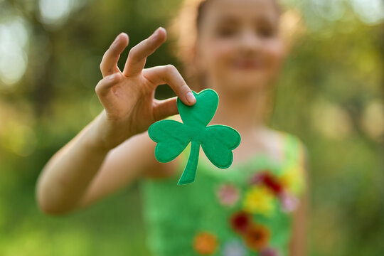 Little girl showing a badge with shamrock symbol
