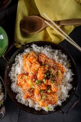 Savory Delights: Close-Up of Deep-Fried Orange Chicken Served on a Bed of Steamed White Rice, Captured in 4K Resolution