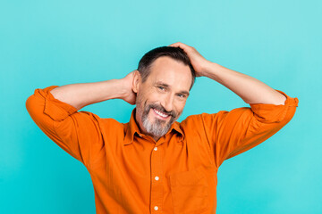 Photo of optimistic handsome man with white gray beard wear stylish shirt arms on head touch hairdo isolated on teal color background