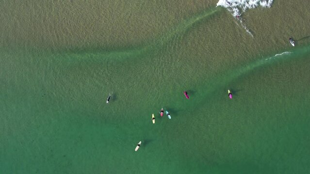 Aerial view of a group of surfers catching waves in the Costa Verde northern Spain