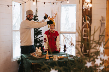 family man father and teenage boy son having fun in living room of cozy winter house, Christmas and New Year holidays and vacation