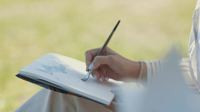 A woman making sketch with blue watercolor