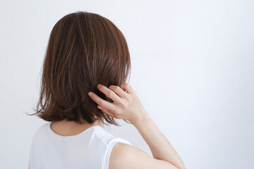 Fototapeta premium 髪の毛を触る女性 ヘアケアイメージ
