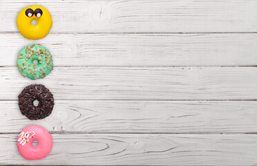 Colorful donuts on a wooden background.