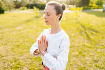 Close-up portrait of yogini female with emotion of serenity and tranquility performing Namaste...