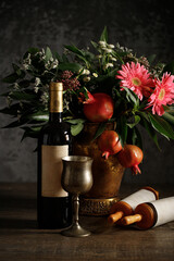 Bouquet of flowers and fruits of pomegranate, wine, torah scroll, concept of jewish new year - rosh hashanah.