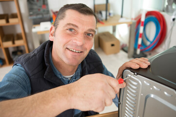 a man fitting a new oven in kitchen