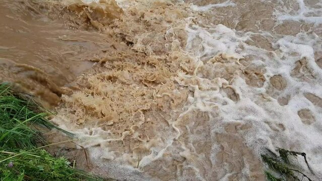 Muddy dirty water mixed with sewage flowing after heavy rains and floods in the city	