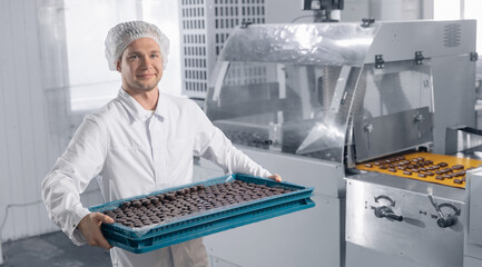 Chocolate candies process making master factory worker. Concept modern food industry production line