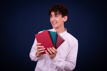 Funny emotional guy is preparing for exams. Student posing on a blue background.