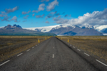 Paved roads in Iceland with snowy mountains in the background
