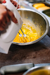 chef with electric mixer in his hands beats the eggs in a bowl on kitchen
