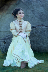 Fototapeta premium A pretty young Asian teenage girl wearing Victorian or Edwardian-era dresses is happy and relaxing on a good day.