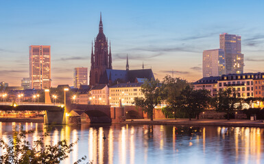 Obraz premium Frankfurt St. Bartholomew's Cathedral and city embankment at sunset.