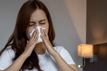 Asian woman suffering from runny nose or nasal blocking. Common cold or flu patient with rhinitis