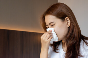 Asian woman suffering from runny nose or nasal blocking. Common cold or flu patient with rhinitis