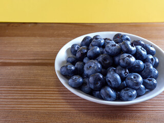 Freshly picked blueberries in a white vintage ceramic bowl. Selective focus, Free text space.