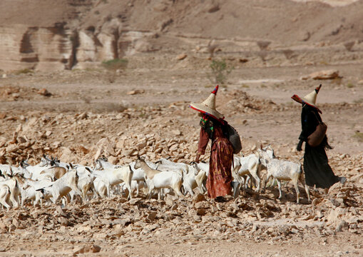 Hadramout women with full black dresses, gloves and high hats; The high hats are supposed to bring fresh air to the head; Yemen;