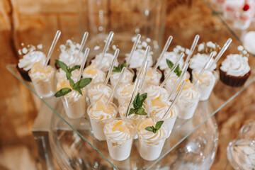 Festive dessert table with sweets. Wedding candy bar, various cakes, chocolates on stands.